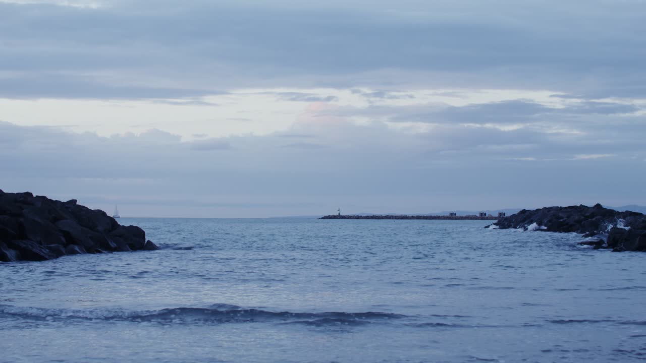vista costera al anochecer con muelle y rocas