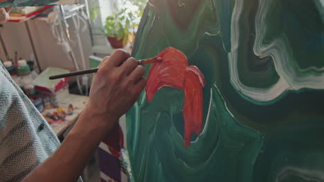 artist using brush and palette as working on abstract painting in studio