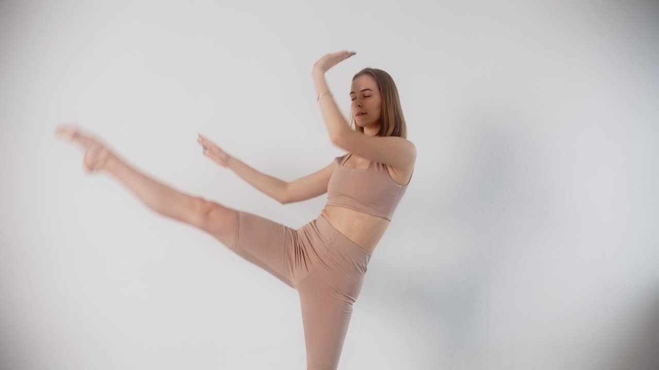 Woman Performing Yoga and Stretching Poses in a Studio Setting