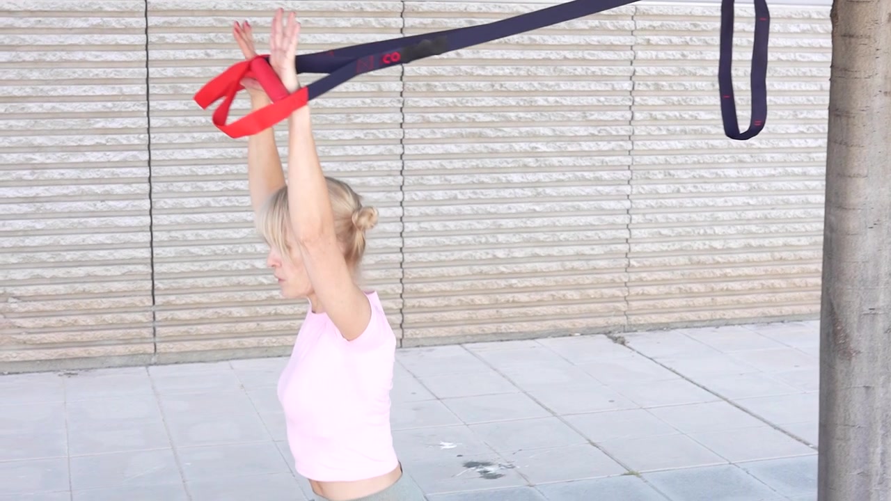 Allenamento total body in sospensione all'aperto con elastici di resistenza per calisthenics e fitness.