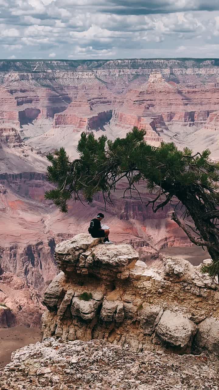 человек, сидящий на краю гранд-каньона