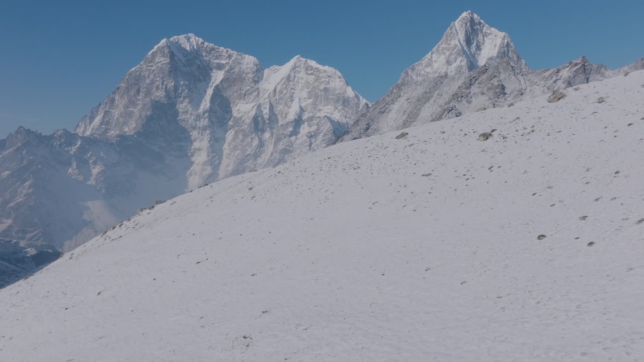 Drone flight over Everest Base Camp trek in Khumbu, Nepal. Morning light reveals 8000m snow-capped peaks standing in unity as strong pillars pride for Nepal, symbols of Himalayan nature conservation
