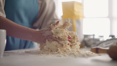 woman is kneading dough in table in home kitchen cooking pizza for family for breakfast closeup of hands