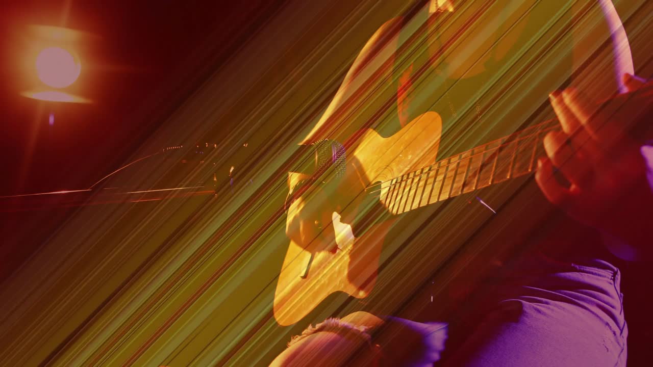 Spotlight cue revealing seated guitarist strumming and adjusting chords toward mic for live set