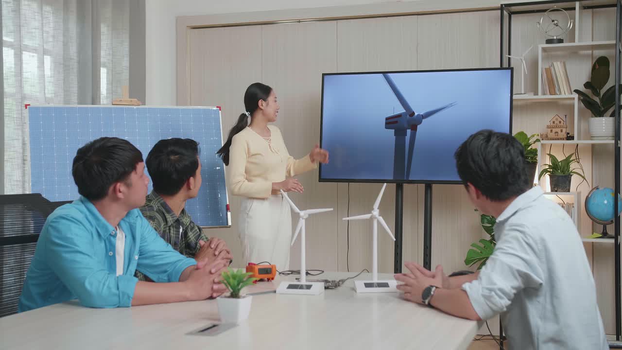 태양전지 를 가진 아시아 여성 엔지니어 가 사무실 에서 풍력 터빈 에 대해 발표 하고 있다