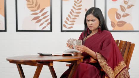 confused indian woman doing household accounts