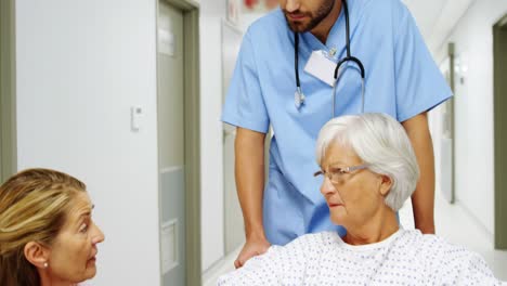 doctora interactuando con un paciente mayor en el pasillo.
