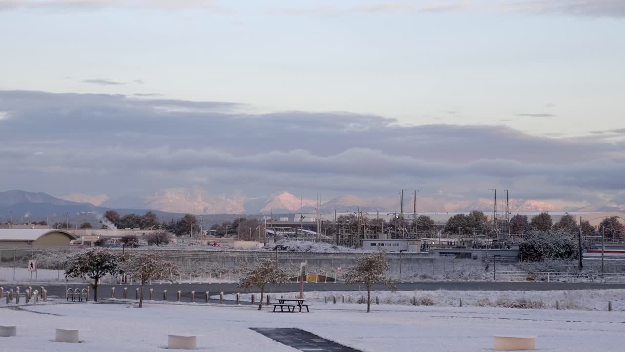 캐나다의 겨울 새벽에 산업 건물 구조가 배경에 있는 빈 눈 덮인 공원