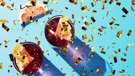 Animation-of-confetti-falling-and-cocktails-on-blue-background