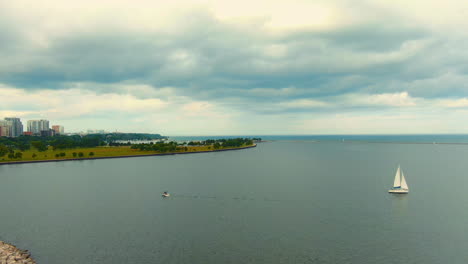 aerial view of milwaukee lakefront with sailboat on cloudy day during summer, lake michigan