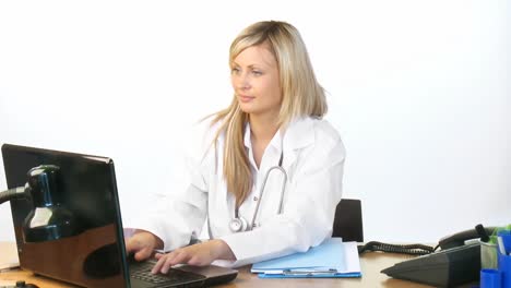 Attraktiver-Blonder-Arzt,-Der-Einen-Laptop-Im-Krankenhausbüro-Benutzt