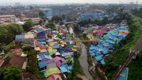 railway bridge and jodipan rainbow village in malang, java indonesia aerial dolly in