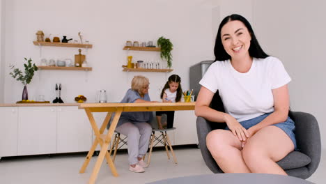 Mujer-Feliz-Y-Hermosa-Sentada-En-Una-Silla-Mirando-La-Cámara-Mientras-Hace-Una-Videollamada-En-Casa-1