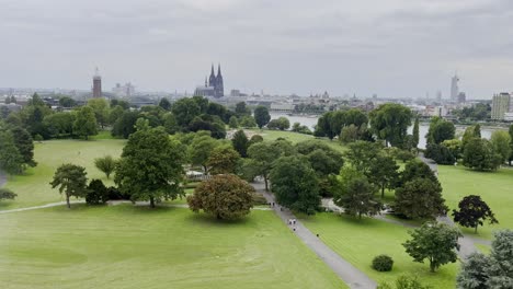 drone shot over rhine park with green white and above the trees with a view of the cathedral and rhine