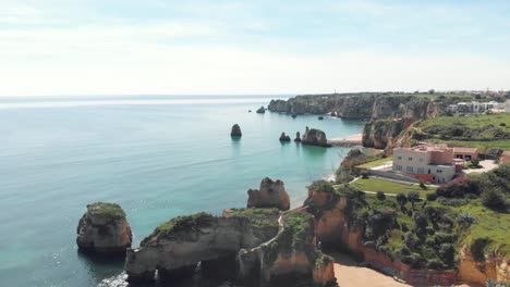 Zerklüftete-Malerische-Küste-Von-Lagos-In-Der-Nähe-Von-Estudante-Beach,-Algarve,-Portugal---Hohe-Panoramische-Aufnahme-Aus-Der-Luft