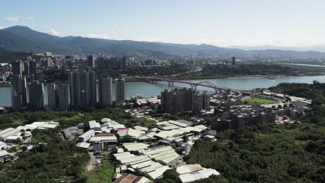 Taipei's-cityscape,-Guandu-Bridge-and-mountains-create-vibrant-aerial-spectacle