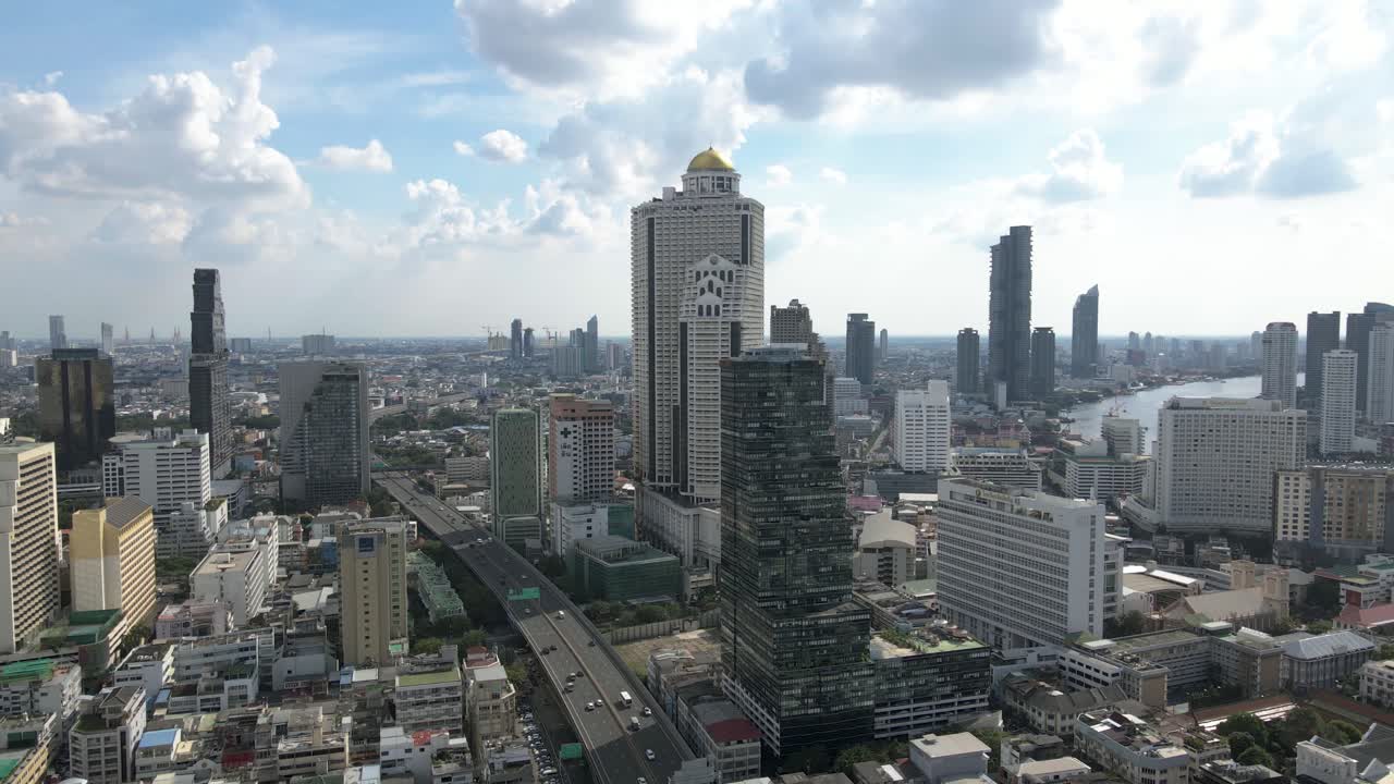 Sweeping aerial view of downtown Bangkok showcasing skyscrapers, roads, and urban sprawl
