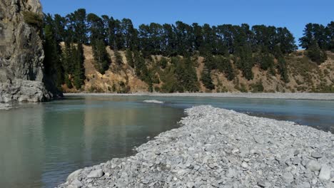 gently-flowing river winds through gorge on a clear summer's day - waimakariri river gorge