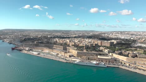 aerial shot over water towards an old city and a cruiseliner