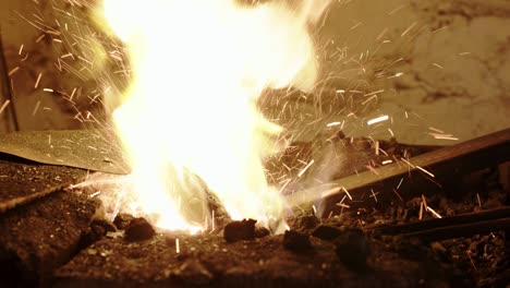 blacksmith heating up iron in his forge