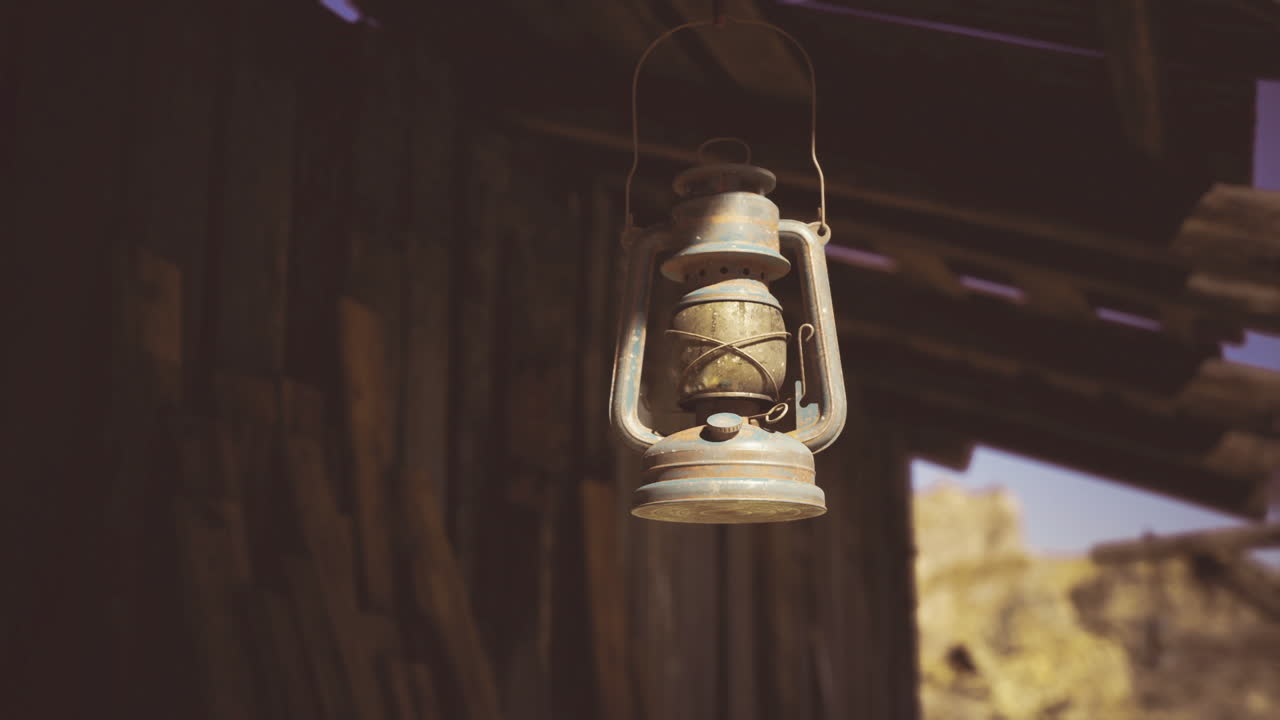 Lanterna dalla luce soffusa contrasta con un paesaggio aspro, in stile cinematografico.