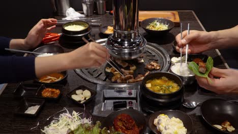 dos personas comiendo samgyeopsal para cenar en un restaurante coreano - primer plano, tiro estático