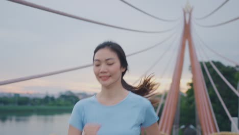 woman running on a bridge at sunset