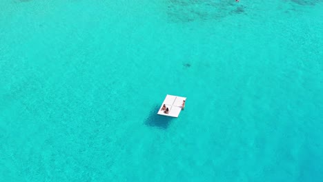 Freunde-Genießen-Es,-Auf-Einem-Schwimmenden-Pad-Im-Wunderschönen-Kristallklaren-Wasser-Des-Karibischen-Ozeans-Zu-Entspannen