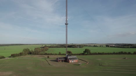 Alejar-La-Vista-Aérea-De-La-Antena-De-Comunicación,-La-Torre-De-Radio-Y-Televisión-En-El-Campo-En-Dinamarca---Tiro-Con-Plataforma-Rodante