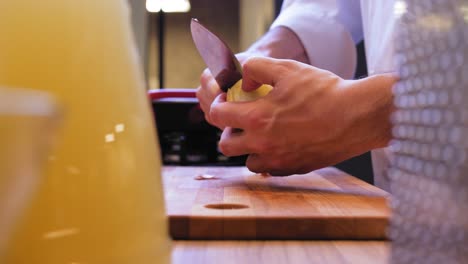 el cocinero pela la cebolla sobre la mesa