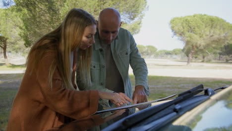 pareja enfocada discutiendo la ruta en el mapa