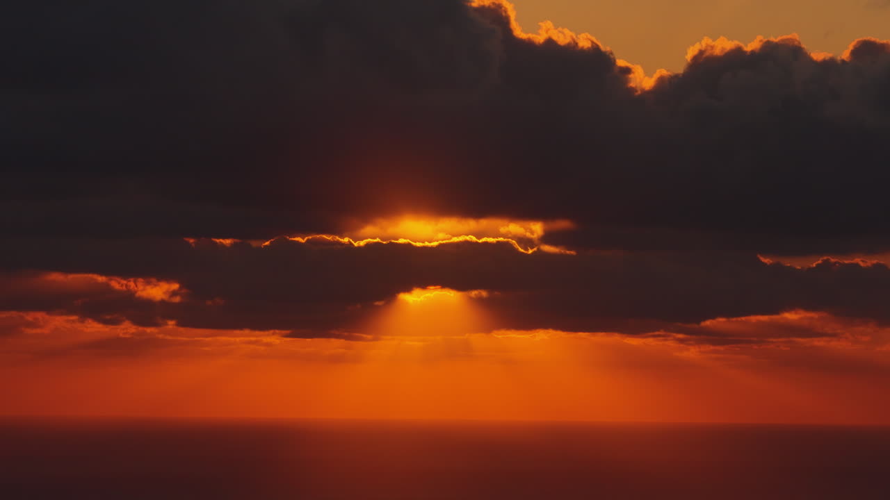 Drohnenaufnahme eines goldenen Sonnenuntergangs, der sich auf dem ruhigen Mittelmeer spiegelt.