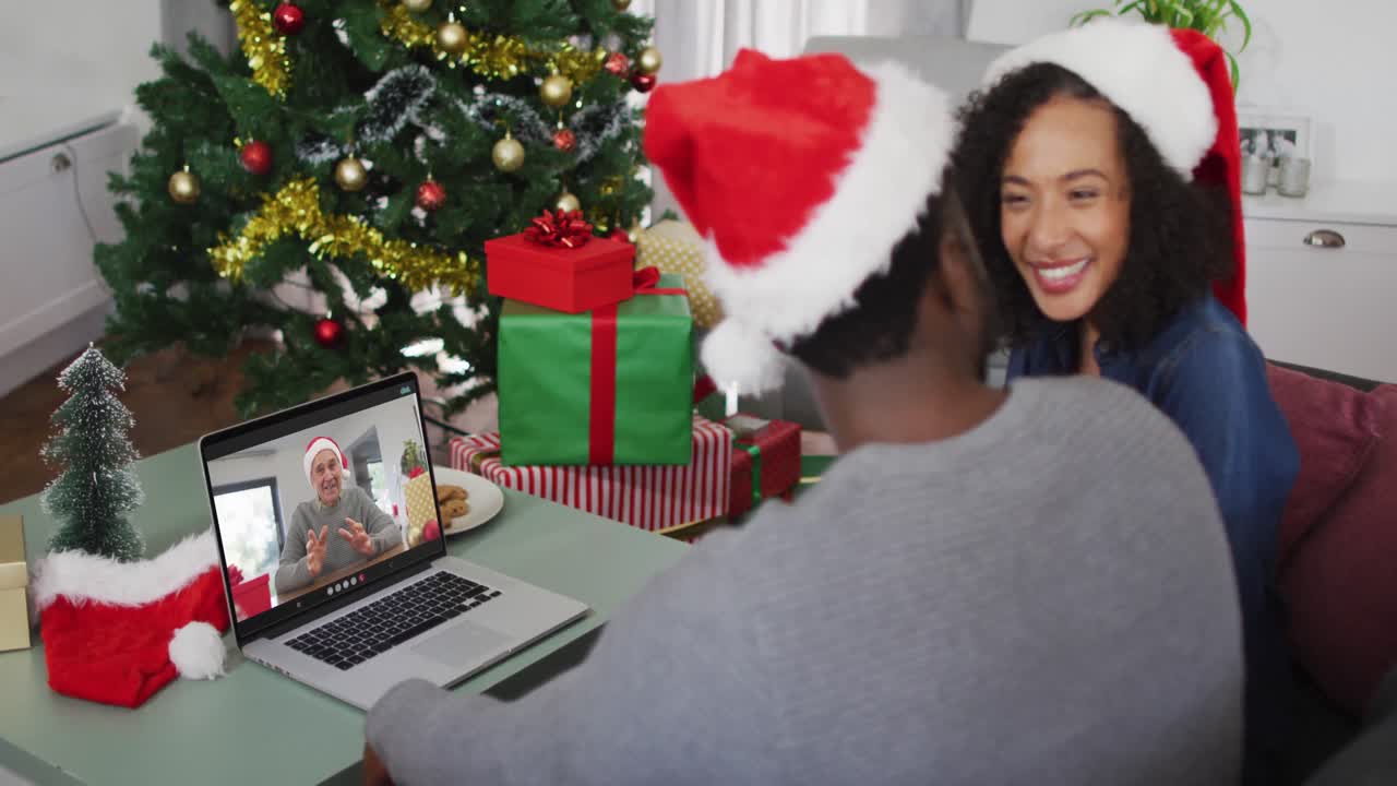 feliz pareja afroamericana en videollamada en computadora portátil con un amigo masculino mayor en tiempo de navidad