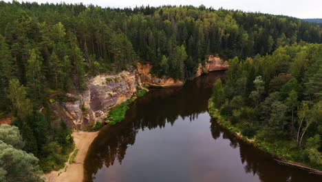 spectacular birds eye reveal over the ancient sandstone cliffs (erglu klintis) and devonian rock formations along the famous gauja river valley in gauja national park, latvia.