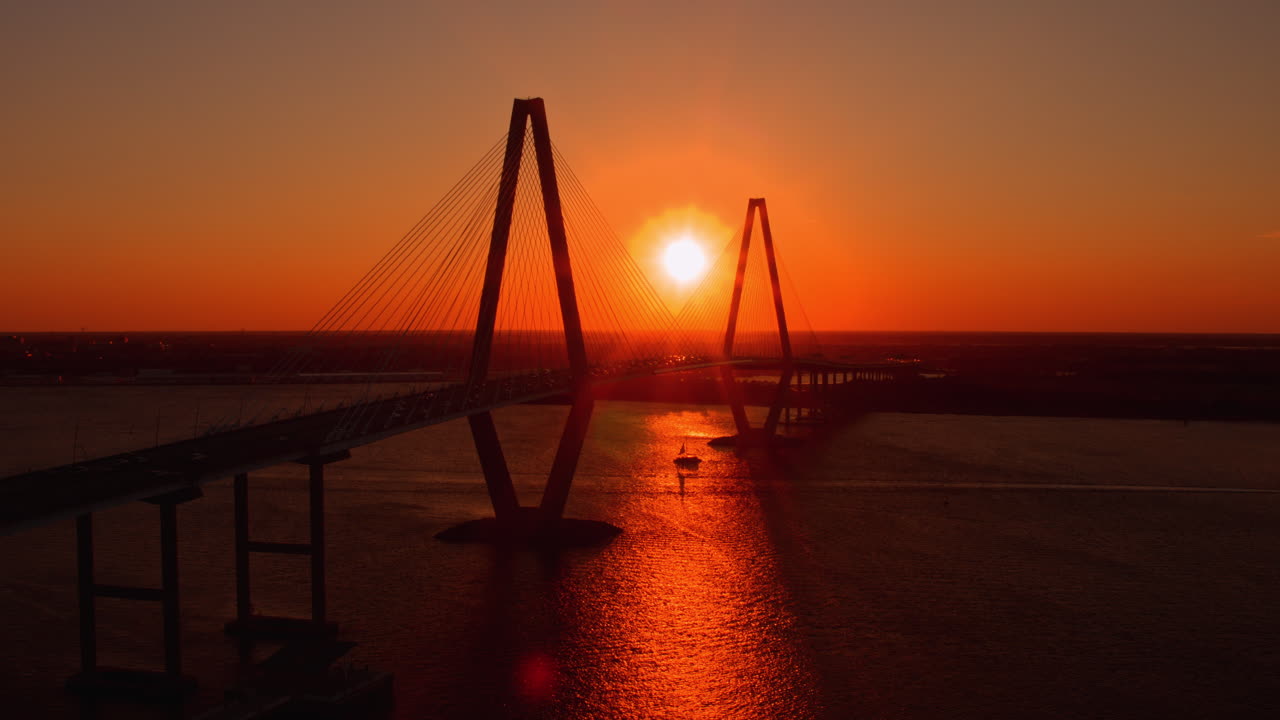 Aerial Drone Shot of Boat Traveling Under Ravenel Bridge at Sunset