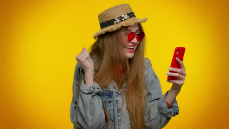 teenager girl tourist with mobile phone celebrating winning holiday resort vacation tickets pass