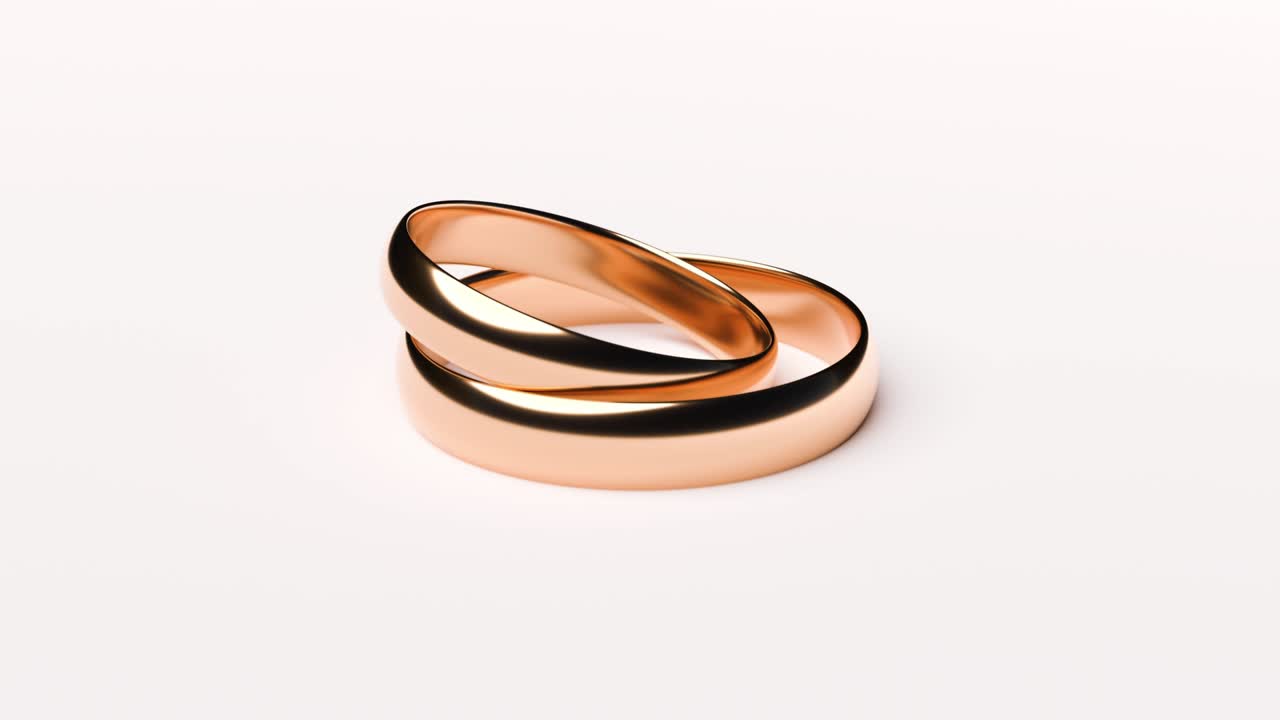 Wedding Golden Rings lie on white rotating background surface