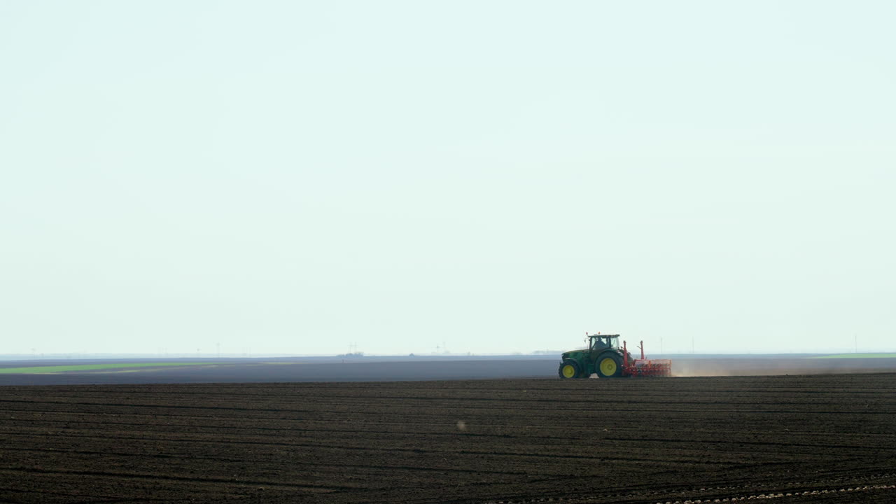 트랙터가 에 씨을 심고 있습니다.