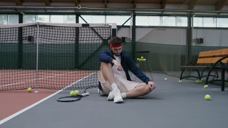 man sitting on tennis court
