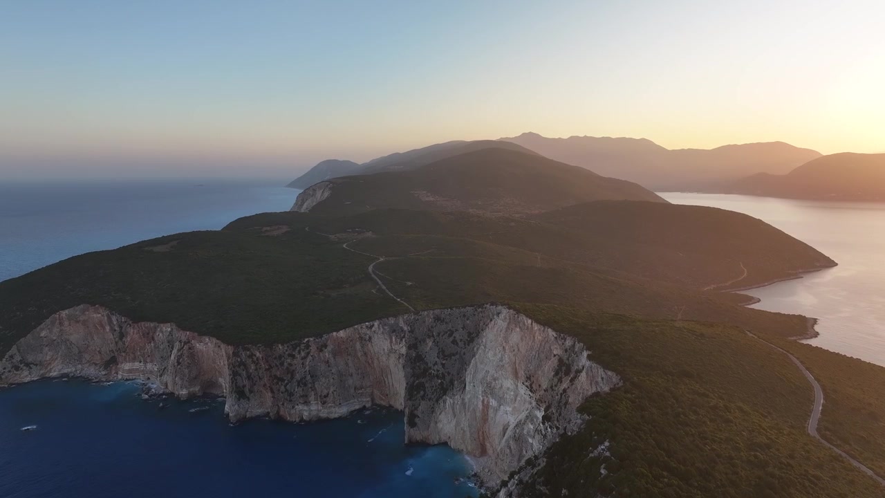 La luce del mattino illumina una penisola montuosa e spettacolari scogliere marine all'alba