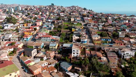 dolly aéreo de coloridas casas de barrio en el cerro playa ancha, mar de fondo, ciudad de valparaíso, chile