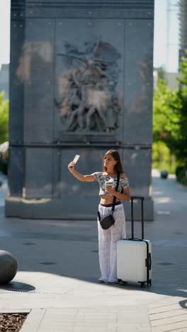 woman traveler taking a selfie near a monument