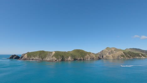 jetboat glides into view on a beautiful, calm sea near the entrance to tory channel, south island