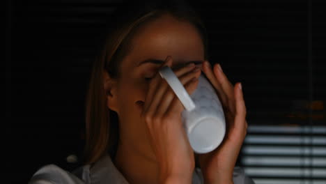 businesswoman drinking coffee at night