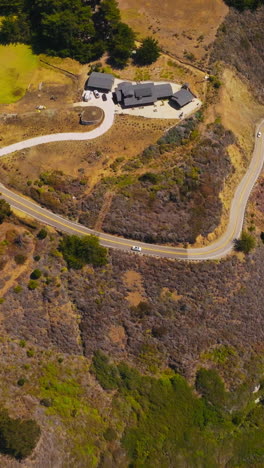 cozy hotel situated on the rocky shore of morro bay. white ways splashing on the craggy rocks of coastline. top view. vertical video