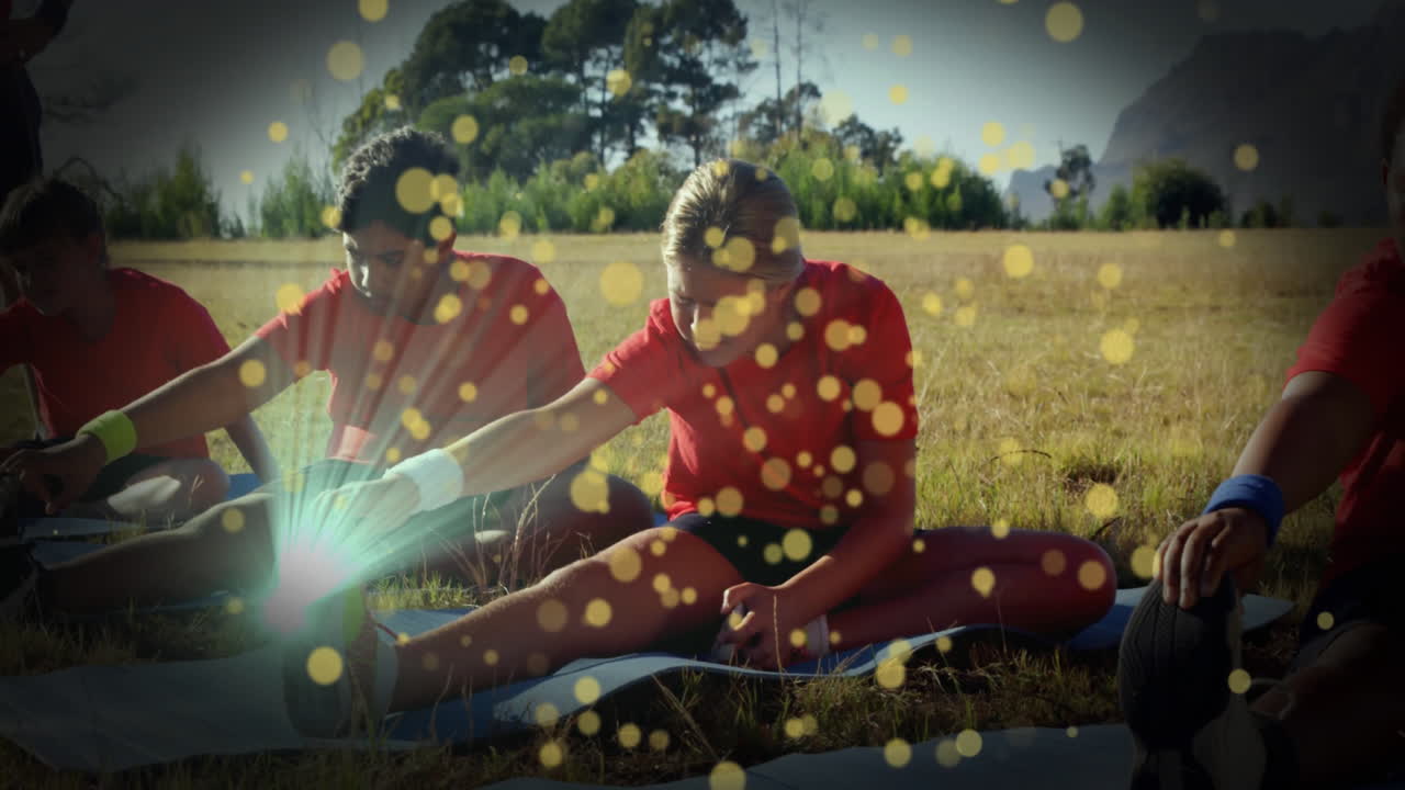 children stretching on blue exercise mats in outdoor fitness, showing golden bokeh lights