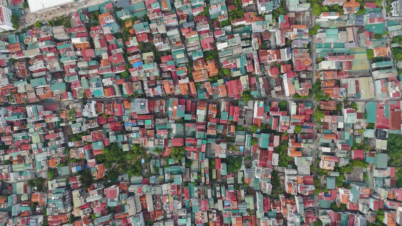 Expansive top-down drone shot of Hanoi, Vietnam, showcasing a dense cityscape of colorful rooftops, narrow streets, and urban housing layout in vibrant detail