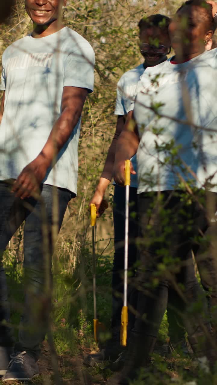 Group of Volunteers Walking and Cleaning in a Sunny Forest