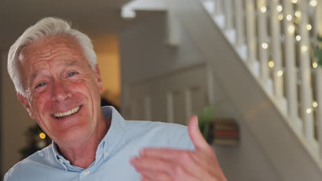 Portrait-Of-Grandfather-Opening-Front-Door-And-Greeting-Family-On-Christmas-Morning