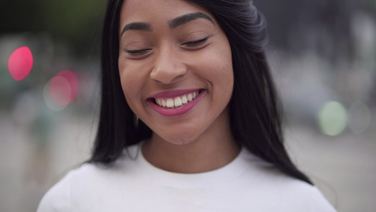 una mujer alegre con una camiseta blanca mirando a la cámara
